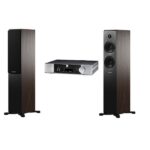 Two tall wood-finished floor-standing speakers flanking a silver stereo receiver.