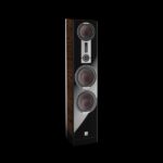 Floor-standing hi-fi speaker with three large drivers and a glossy black front panel, wood sides, and a small control/display near the top edge.