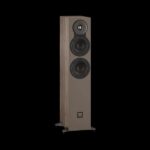 Tall floor-standing speaker with three drivers in a wood veneer cabinet on a black background, featuring a tweeter and two mid/bwoofers and a small logo near the base